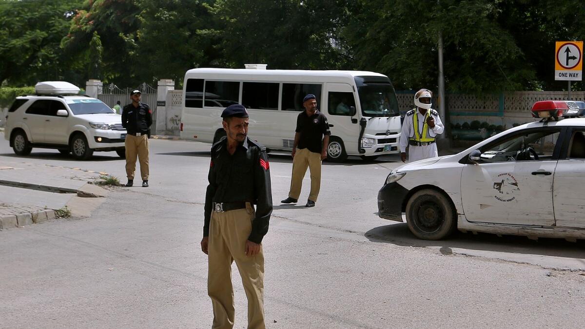 Police officers stand guard as the England team head to their hotel upon their arrival in Karachi on Thursday.— AP