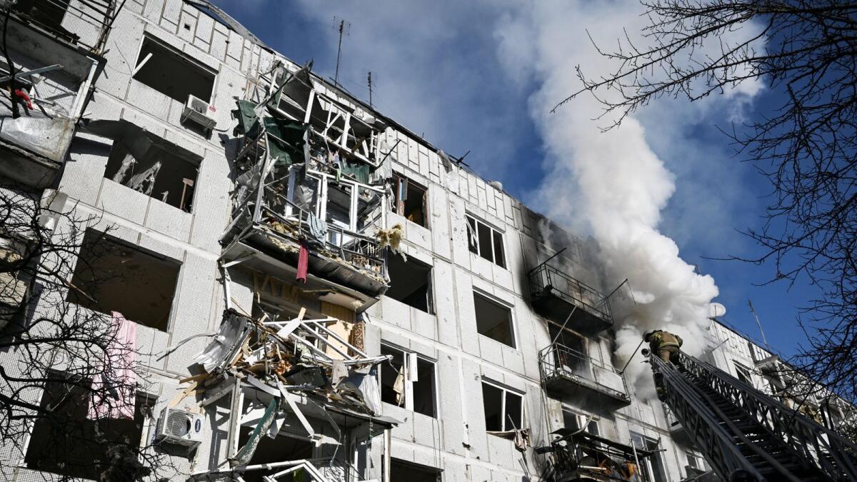 Firefighters work on a fire on a building after bombings on the eastern Ukraine town of Chuguiv on February 24, 2022, as Russian armed forces are trying to attack Ukraine from several directions, using rocket systems and helicopters to attack Ukrainian position in the south, the border guard service said. Photo: AFP