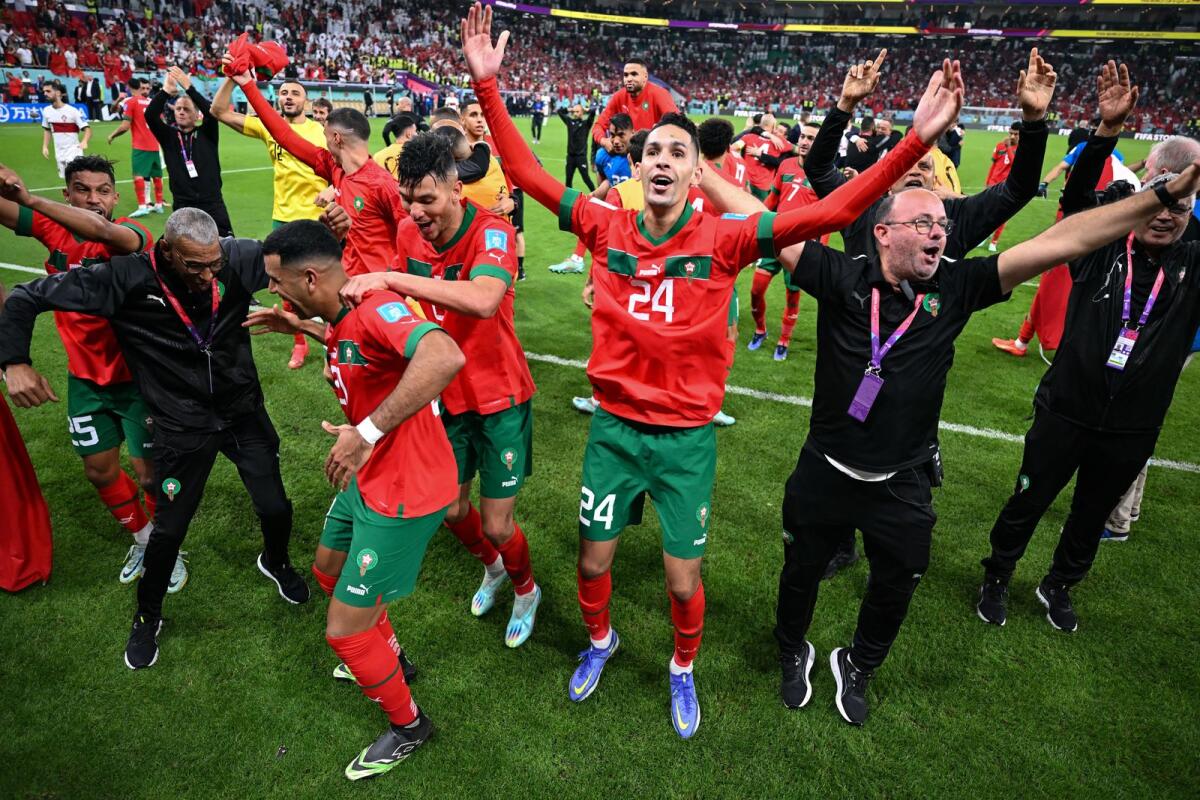 Morocco players and staff members celebrate after defeating Portugal at the World Cup. — AFP file