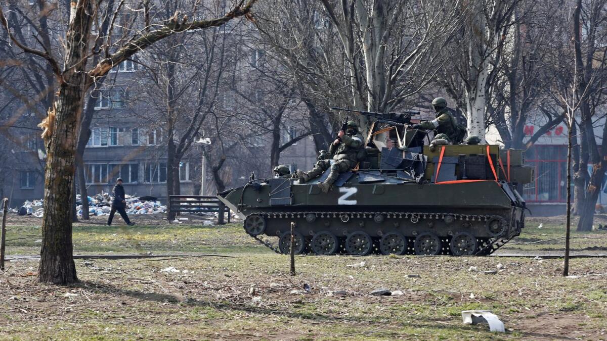 Service members of pro-Russian troops are seen atop of an armoured vehicle. (Reuters)