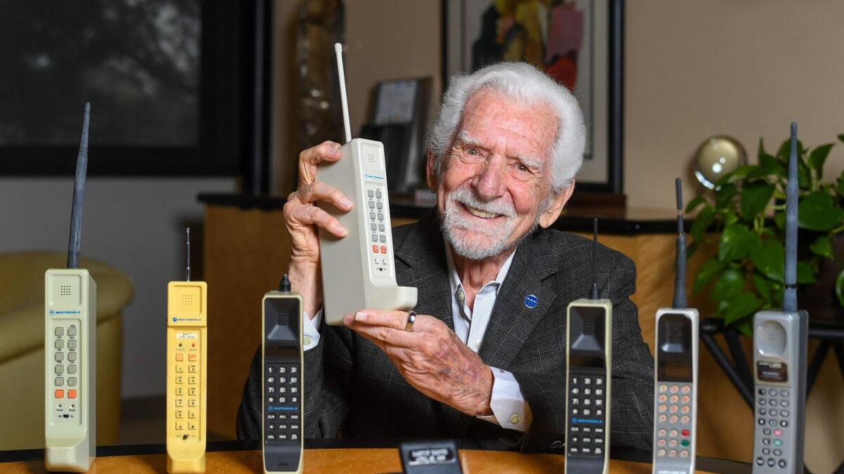 Engineer Martin Cooper holds a contemporary copy of the original cell phone he used to make the first cell phone call on April 3, 1973, in Del Mar, California. - AFP