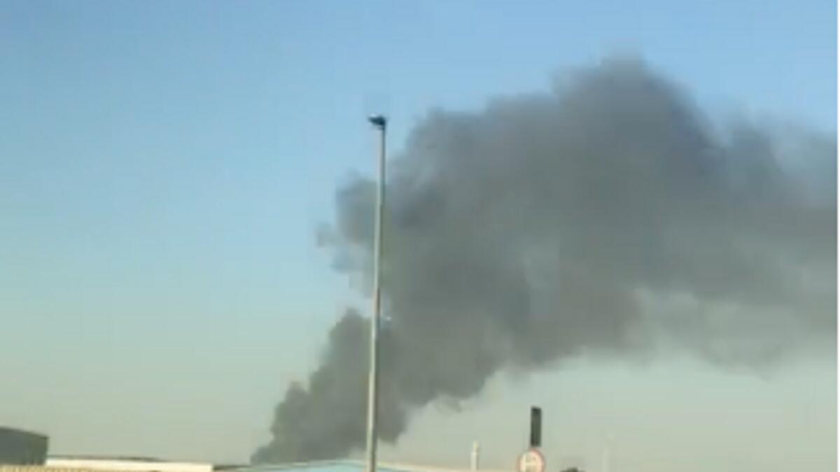 A screengrab from a video shared by a Khaleej Times reader shows black smoke billowing from an industrial area in Sharjah