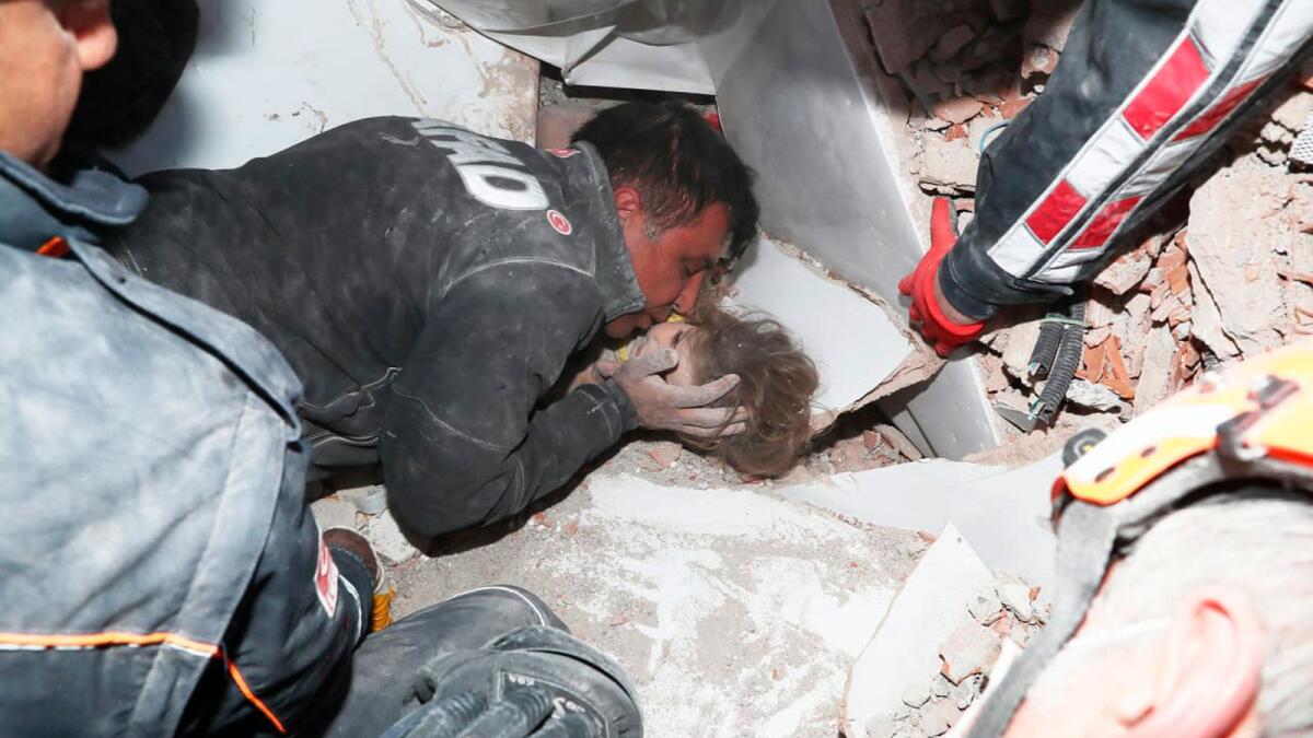 Rescue workers surround Ayda Gezgin in the Turkish coastal city of Izmir, after they have pulled the girl out alive from the rubble of a collapsed apartment building.