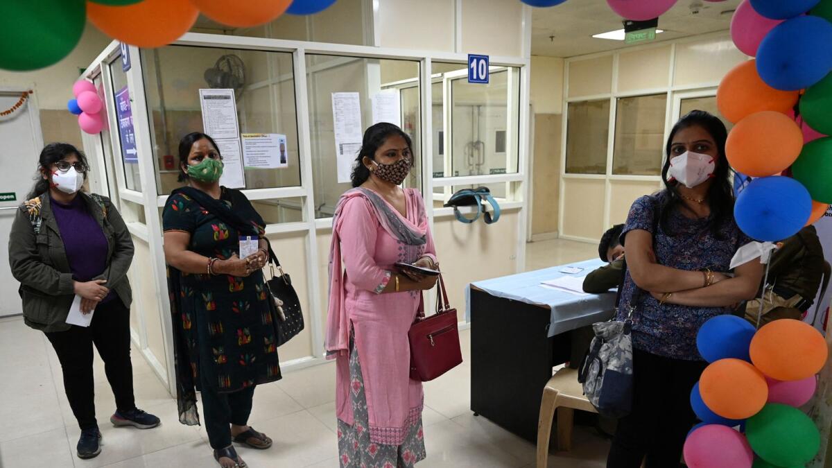 Women wait for their turn to receive a dose of Covid-19 vaccine at a government hospital in New Delhi on Monday. Photo: AFP