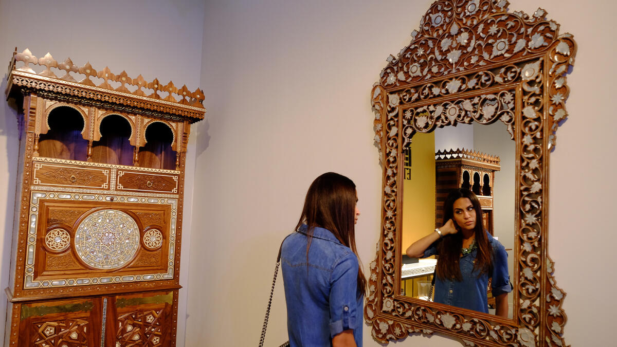 MIRROR MIRROR ON THE WALL ... A woman takes a look at a fancy handmade mirror displayed at the Etqaan Pavilion.