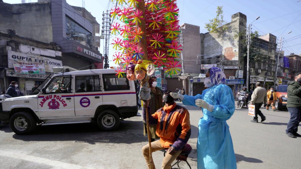 A health worker collects a swab sample from a roadside vendor to test for Covid-19 during a weekend lockdown in Jammu. — AP