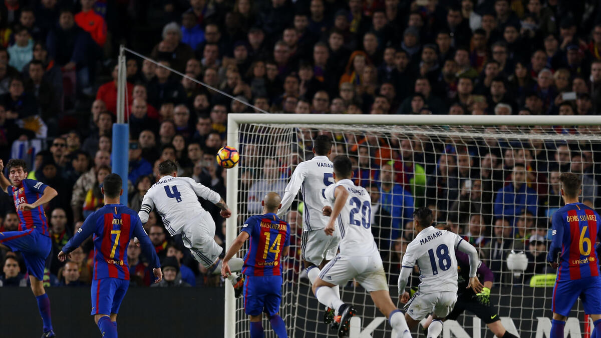Real Madrid's Sergio Ramos, third left, heads the ball to score his side's first goal during the Spanish La Liga soccer match between FC Barcelona and Real Madrid at the Camp Nou stadium in Barcelona, Spain, Saturday, Dec. 3, 2016. Ramos scored the equalizer goal and the match ended in a 1-1 draw. (AP Photo/Francisco Seco)