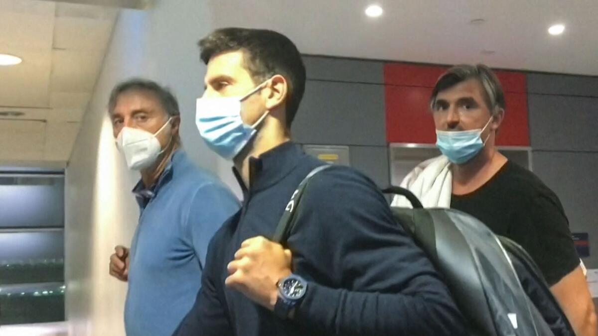 This screen grab from AFPTV shows Novak Djokovic (centre) walking ahead of his coach Goran Ivanisevic (right) after they disembarked from their plane at the airport in Dubai on Monday. (AFP)