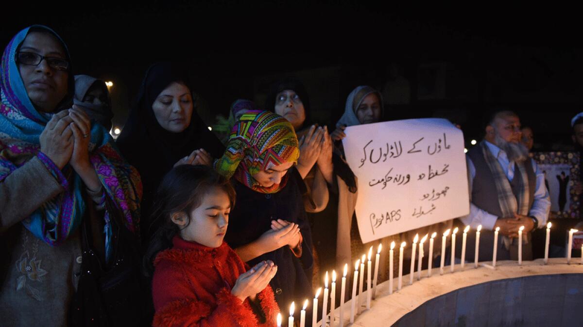 Relatives of the 2014 Peshawar school attack victims light candles for the victims of the Bacha Khan university in Peshawar.