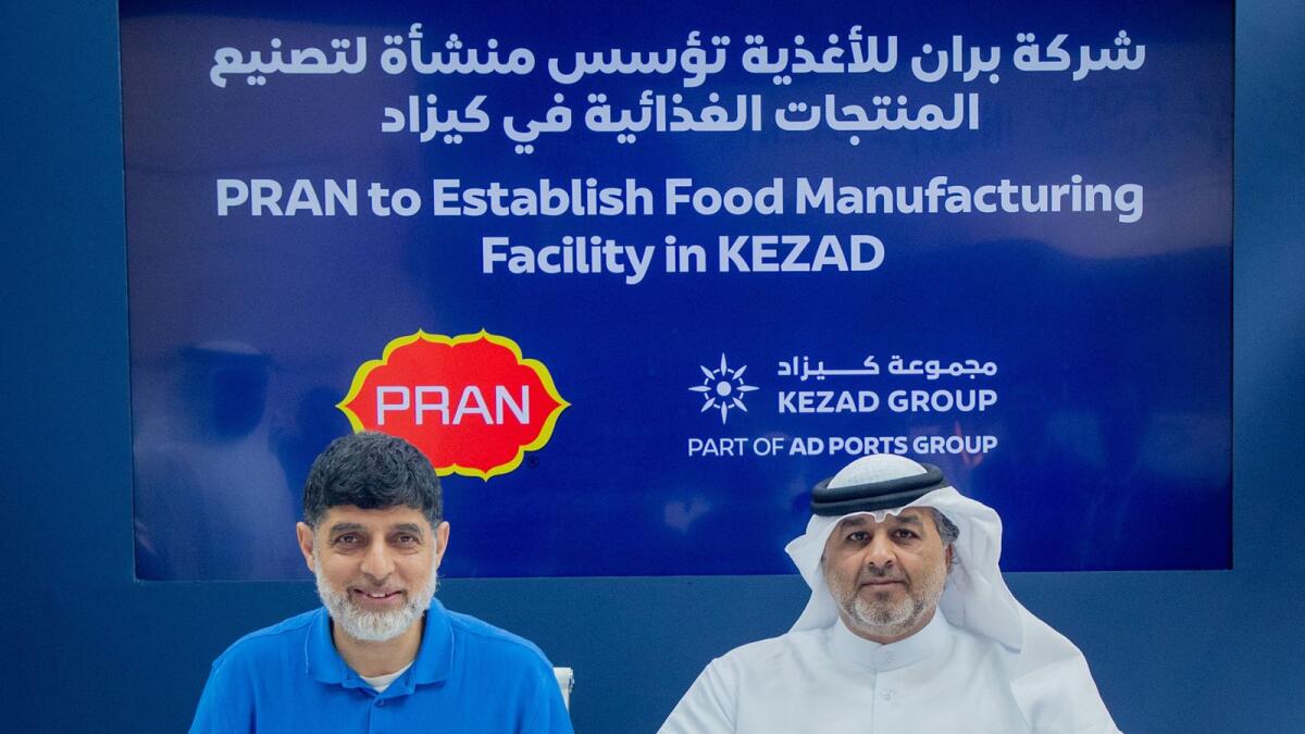 Mohamed Al Khadar Al Ahmed, CEO of Kezad Group, and Hasan Mahbub, managing director of Emerging World FZC, signing the agreement. — Wam