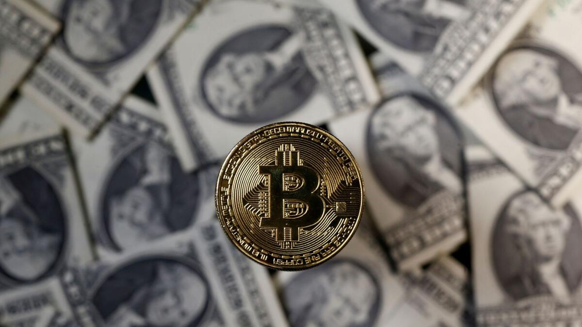 A bitcoin (virtual currency) coin placed on dollar banknotes is seen in this illustration picture. Bitcoin’s rally registered further momentum after mainstream investors and companies, such as Tesla, Mastercard and BNY Mellon announced plans to invest in the cryptocurrency. — Reuters