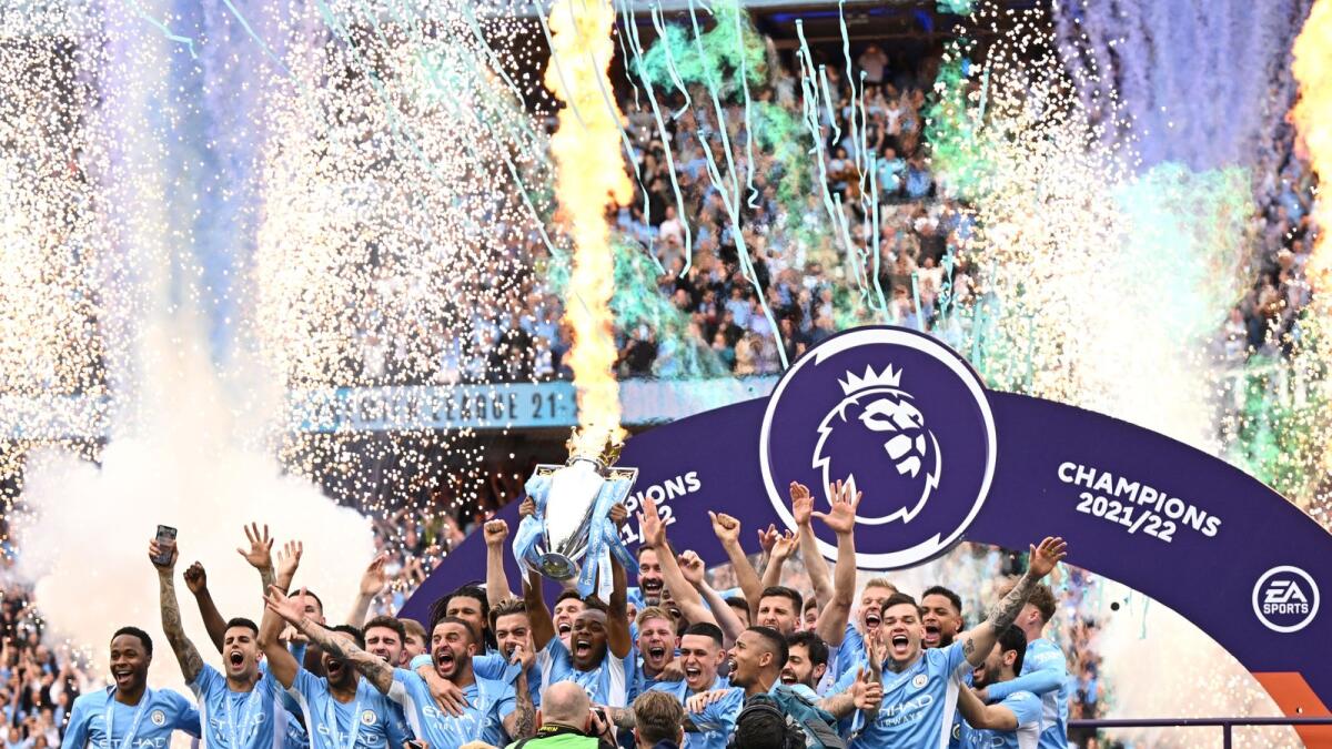 Manchester City players celebrate with the Premier League trophy at the Etihad Stadium on Sunday. — AFP