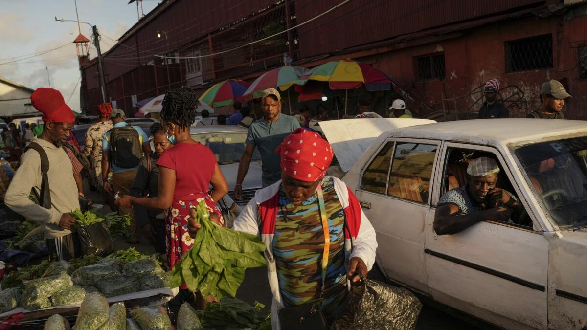 Shoppers look at vegetables at the Stabroek Market in Georgetown, Guyana. More than 40% of the population lived on less than $5.50 a day when oil production began in December 2019. — AP