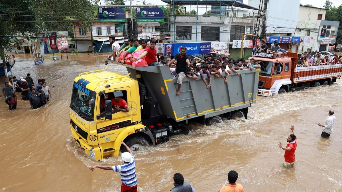Indian passengers travel in a truck to a safer place as flood waters ravaged the National Highway 47 in Ernakulam district of Kochi.- AFP