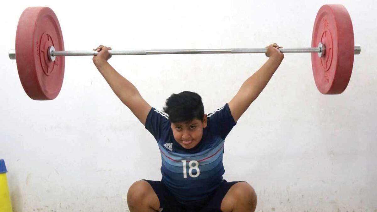 An Iraqi boy lifts weights as he trains at the weightlifting club in the town of Badra near the Iraq-Iran border. — AFP