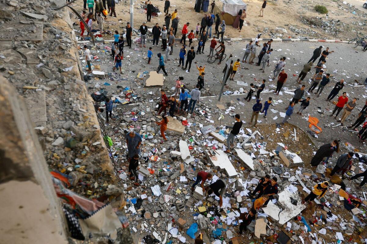 People walk among debris at the site of an Israeli strike on the apartment building. Photo: Reuters