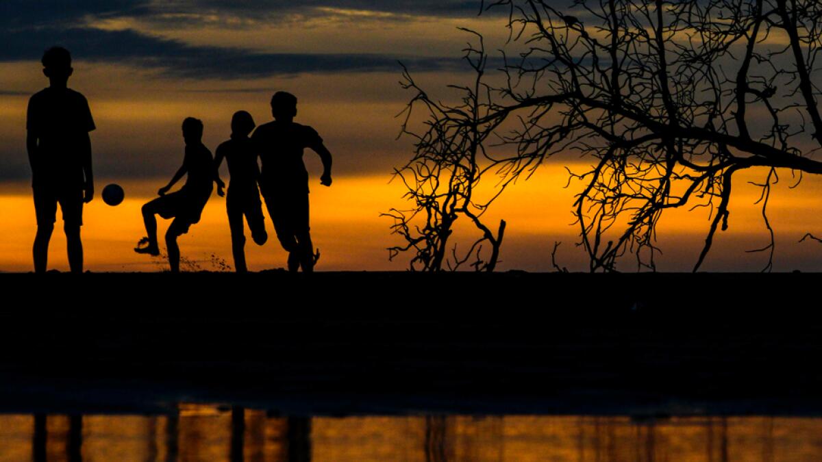 People play football during sunset at the Meulaboh beach in Aceh province, Indonesia. Photo: AFP