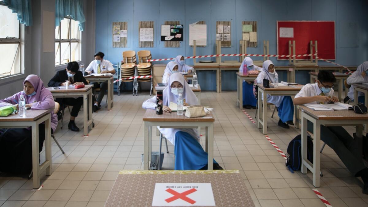 Students wearing face mask and maintaining social distancing at class room during the first day of school reopen at a high school in Putrajaya, Malaysia. Photo: AP