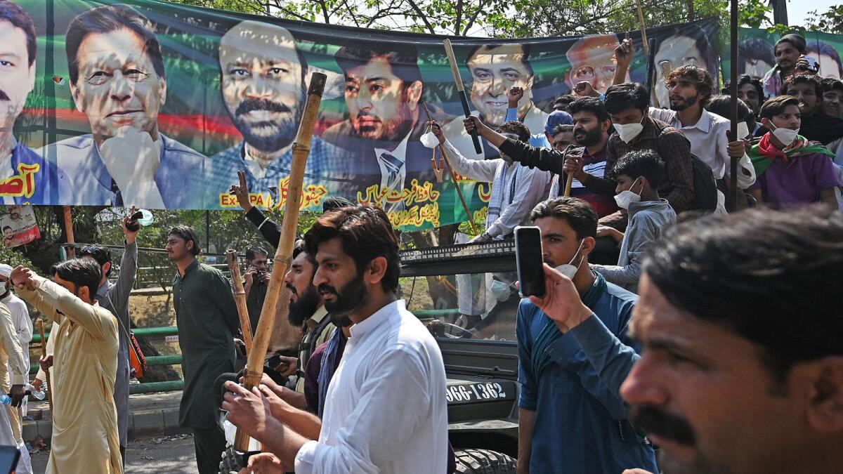 Supporters of former  prime minister Imran Khan shout slogans as they march towards Khan's residence in Lahore on Thursday. — AFP