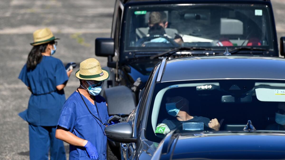 Health care workers administer Covid-19 tests at a drive-through clinic in Sydney. –AP