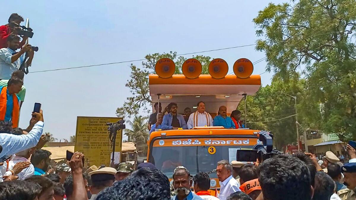 BJP national president JP Nadda with Karnataka CM Basavaraj Bommai and Kannada actor Kiccha Sudeep during a roadshow in support of Bommai ahead of Karnataka Assembly elections in Haveri district on Wednesday. — PTI