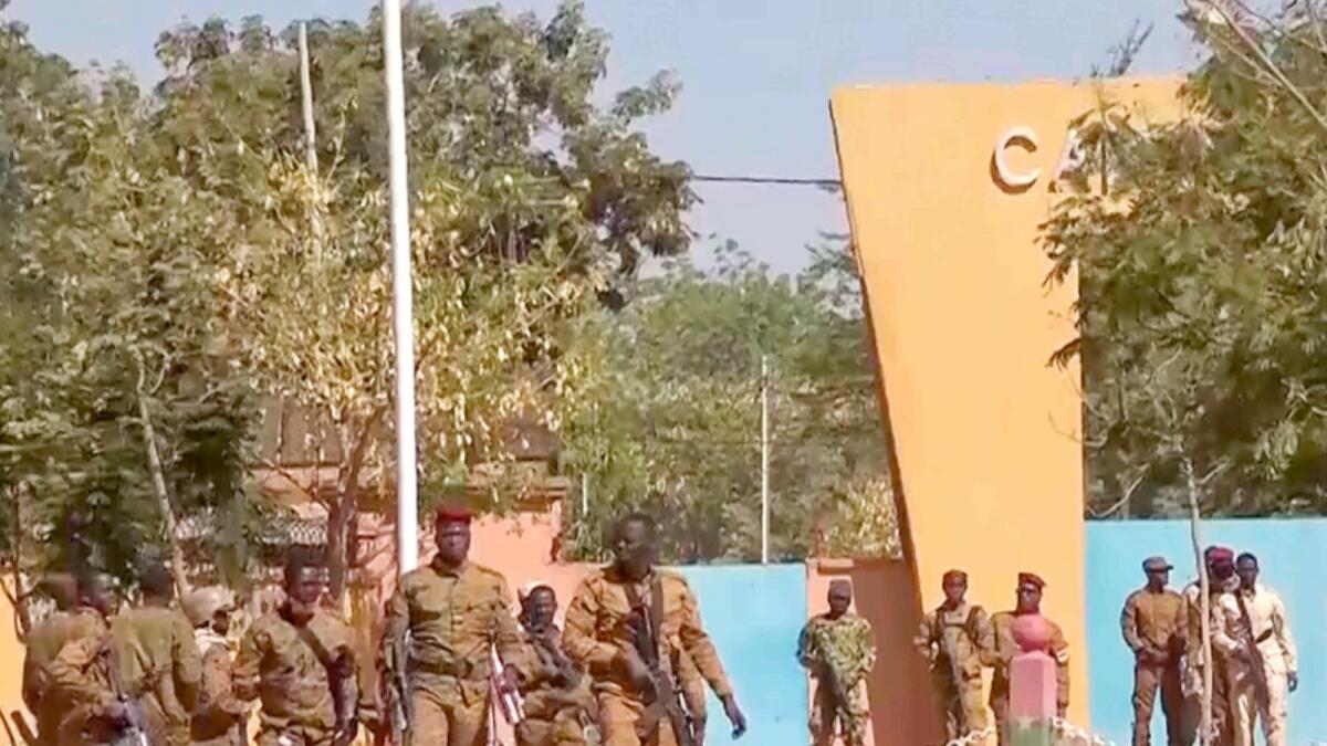 In this image made from video, Burkina Faso mutinous soldiers walk outside the Guillaume Ouedraogo military camp in Ouagadougou. — AP
