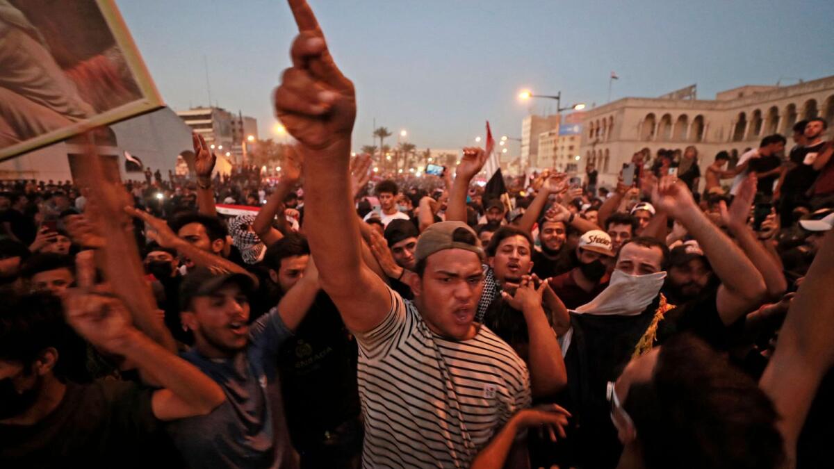 Iraqi protesters gesture during a rally at Al Jumhuriya bridge leading to the capital Baghdad's high-security Green Zone on Saturday. — AFP
