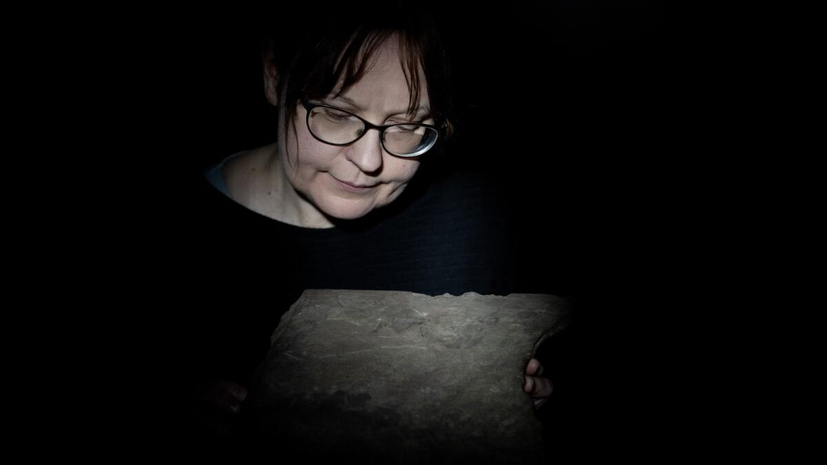 Kristel Zilmer, professor of written culture and iconography at the Museum of Cultural History, displays a runestone found at Tyrifjorden, Norway, on Thursday, Jan. 12, 2023.  — AP