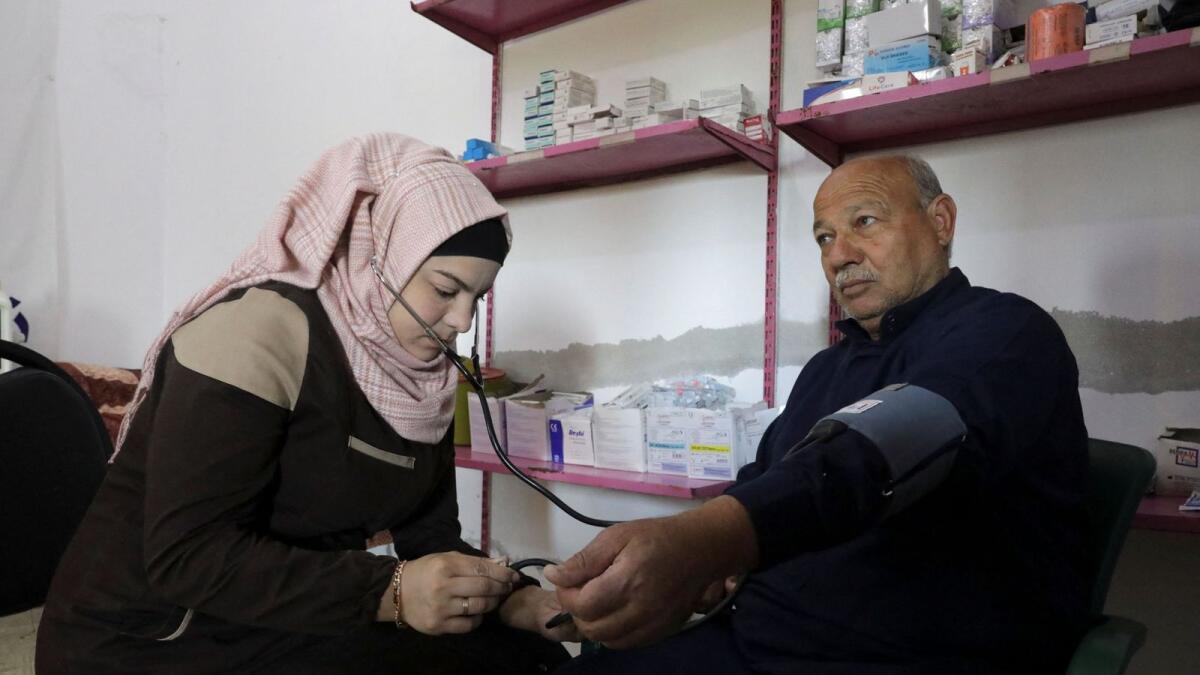 Salam Mahmoud checks the blood pressure of a man at a White Helmets centre in Idlib province. — Reuters file