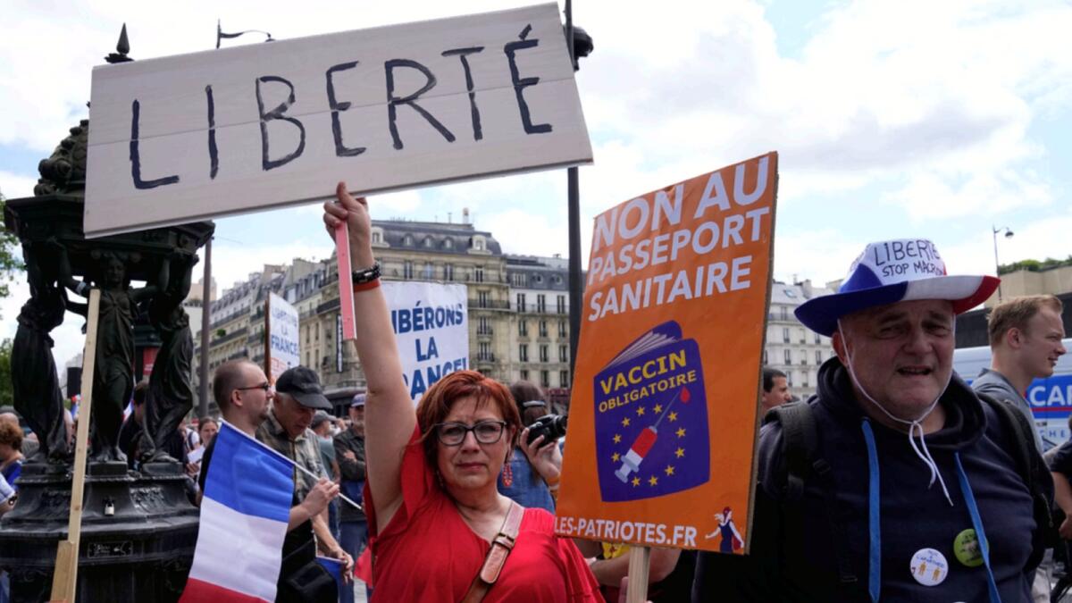 A protestor holds a sign which reads in French, 'freedom' and 'no to the Covid passport' as she attends a demonstration in Paris. — AP