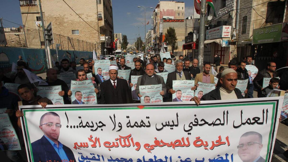 Relatives and supporters of hunger striking Palestinian prisoner Mohammed Al Qiq hold posters and portraits. AFP photo