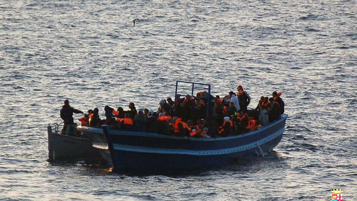 Migrants stand on an Italian Navy boat during a rescue operation near the Italian island of Lampedusa in this 2014 file photo.