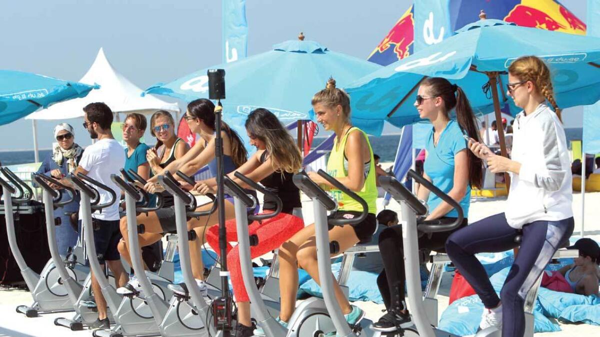 Participants get going on stationary bikes at the Dubai Fitness Challenge weekend carnival at Kite beach. — Photo by Shihab