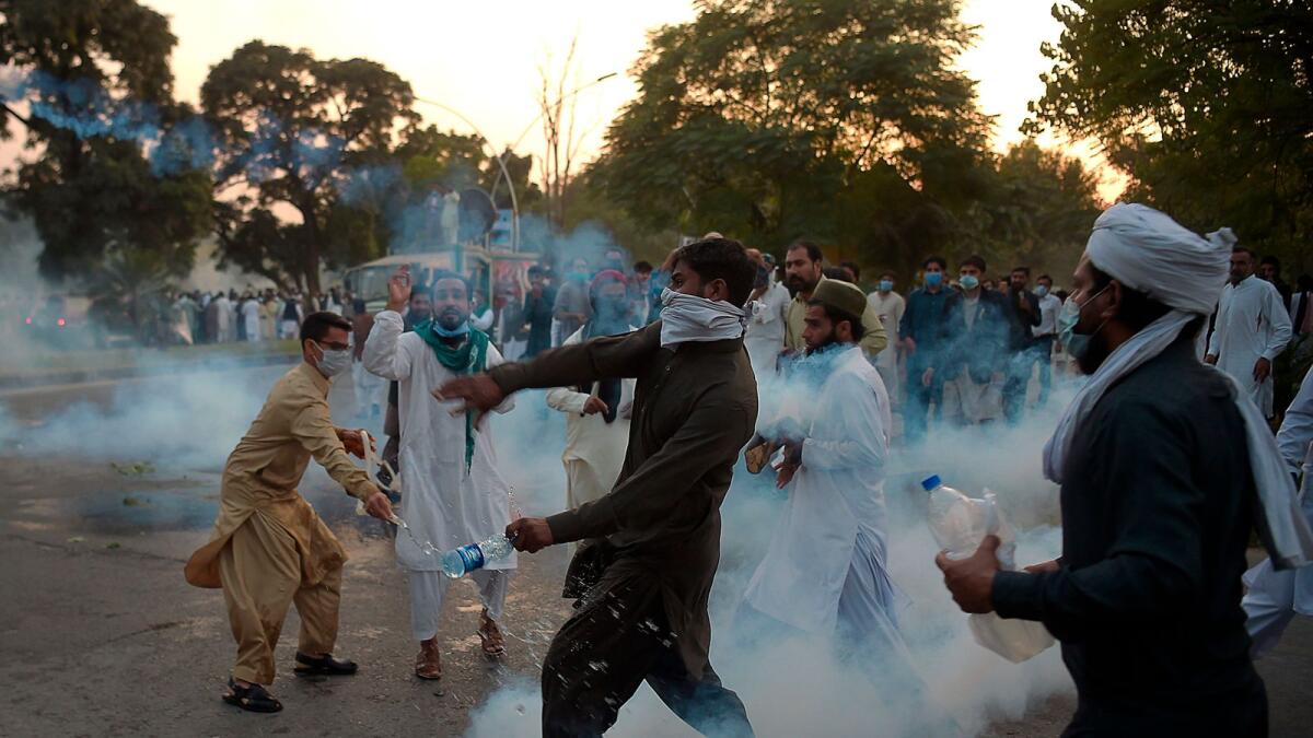 Pakistani protesters return tear gas shells during a demonstration in Islamabad on Friday.