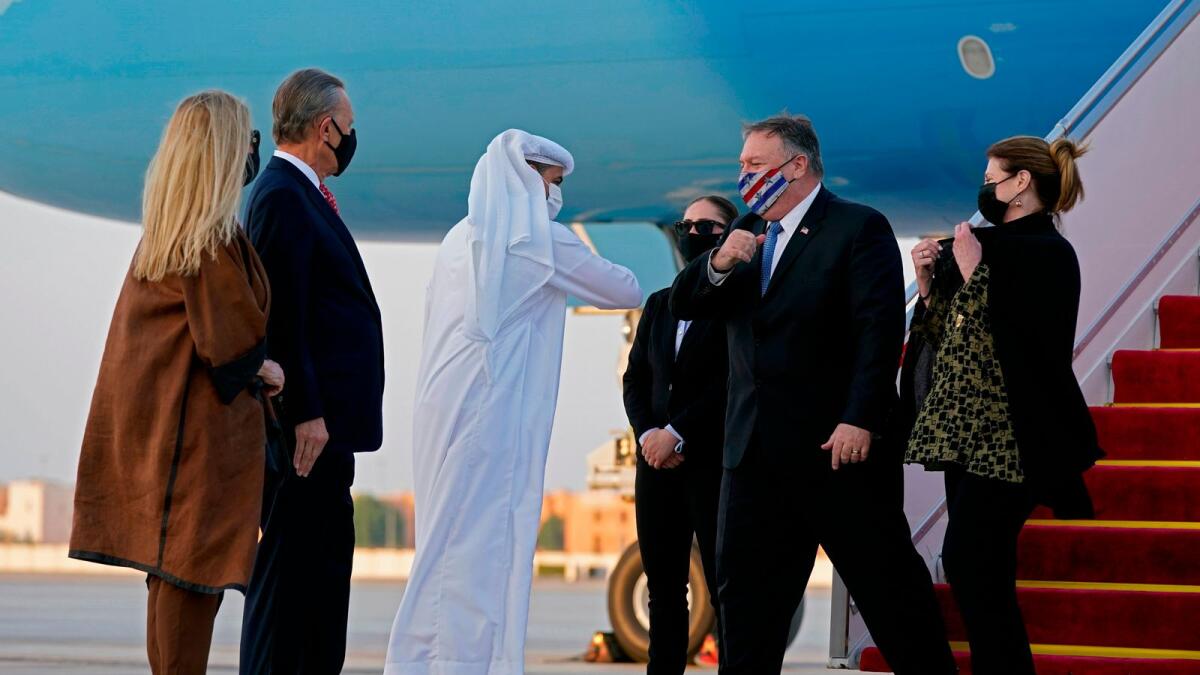 UAE's Protocol Chief Shihab Al Faheem greets with an elbow-bump US Secretary of State Mike Pompeo (C-R) alongside his wife Susan (R) in the presence of US Ambassador to the United Arab Emirates John Rakolta (L) and his wife Terry, at Al Bateen Executive Airport in Abu Dhabi on November 20, 2020.  AFP