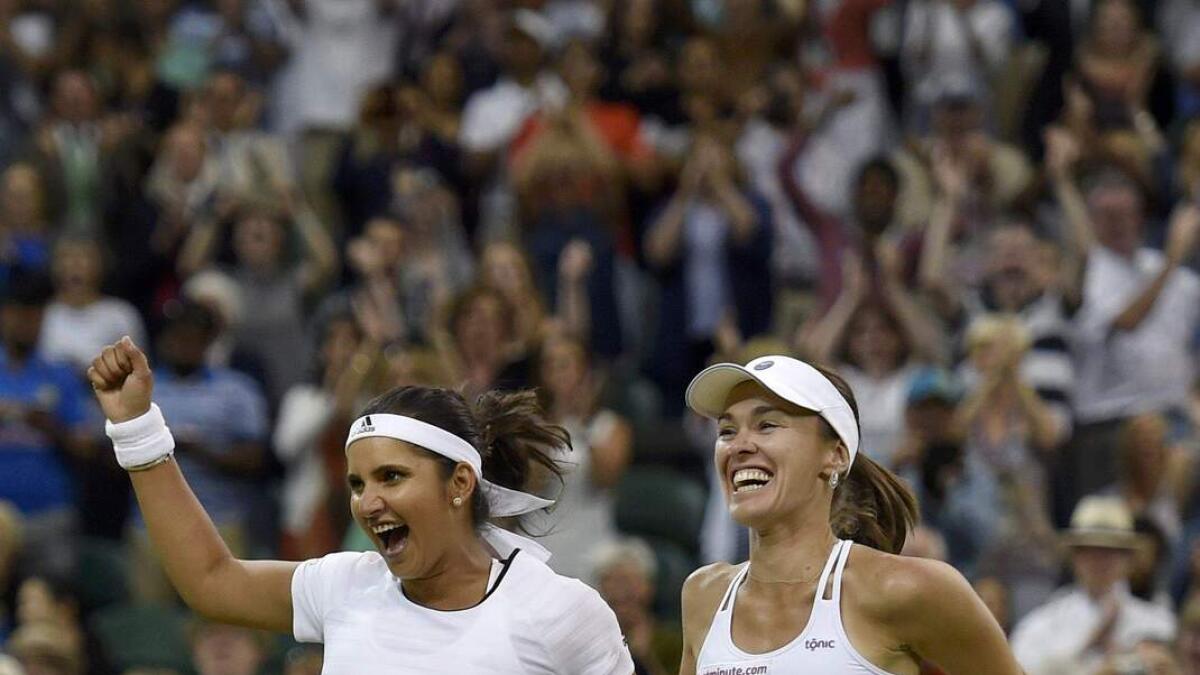 Martina Hingis of Switzerland and Sania Mirza of India celebrate after winning their Women's Doubles Final match against Elena Vesnina and Ekaterina Makarova of Russia at the Wimbledon Tennis Championships in London, July 11, 2015.