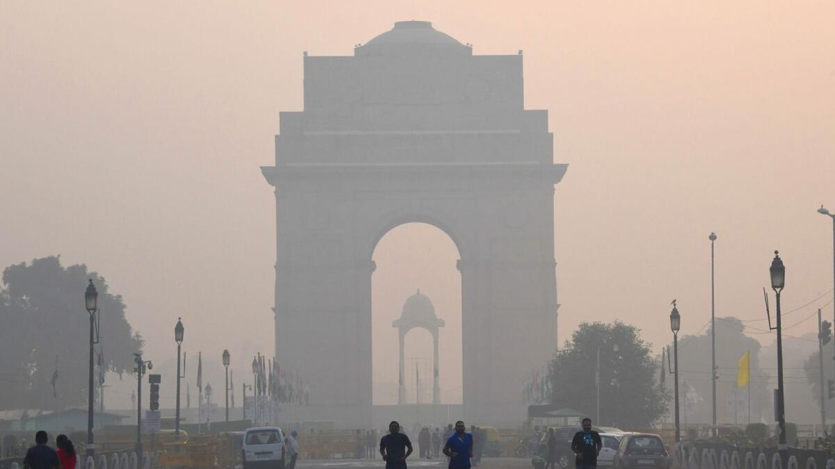 Indian pedestrians walk near the India Gate monument amid heavy smog conditions in New Delhi. AFP file photo