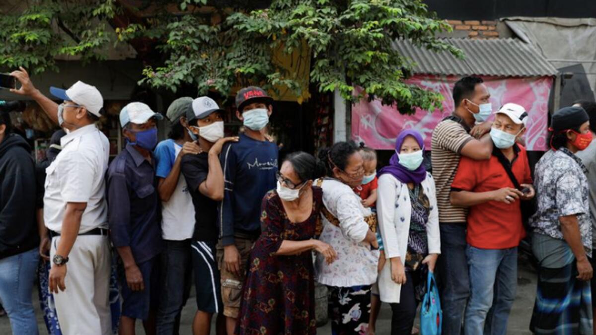 Indonesians wait in line to receive assistance. Photo: Reuters