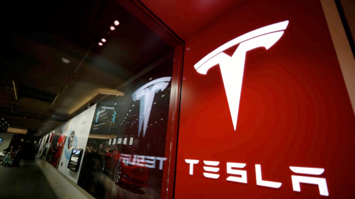 A sign bearing the company logo outside a Tesla store in Cherry Creek Mall in Denver. — AP file