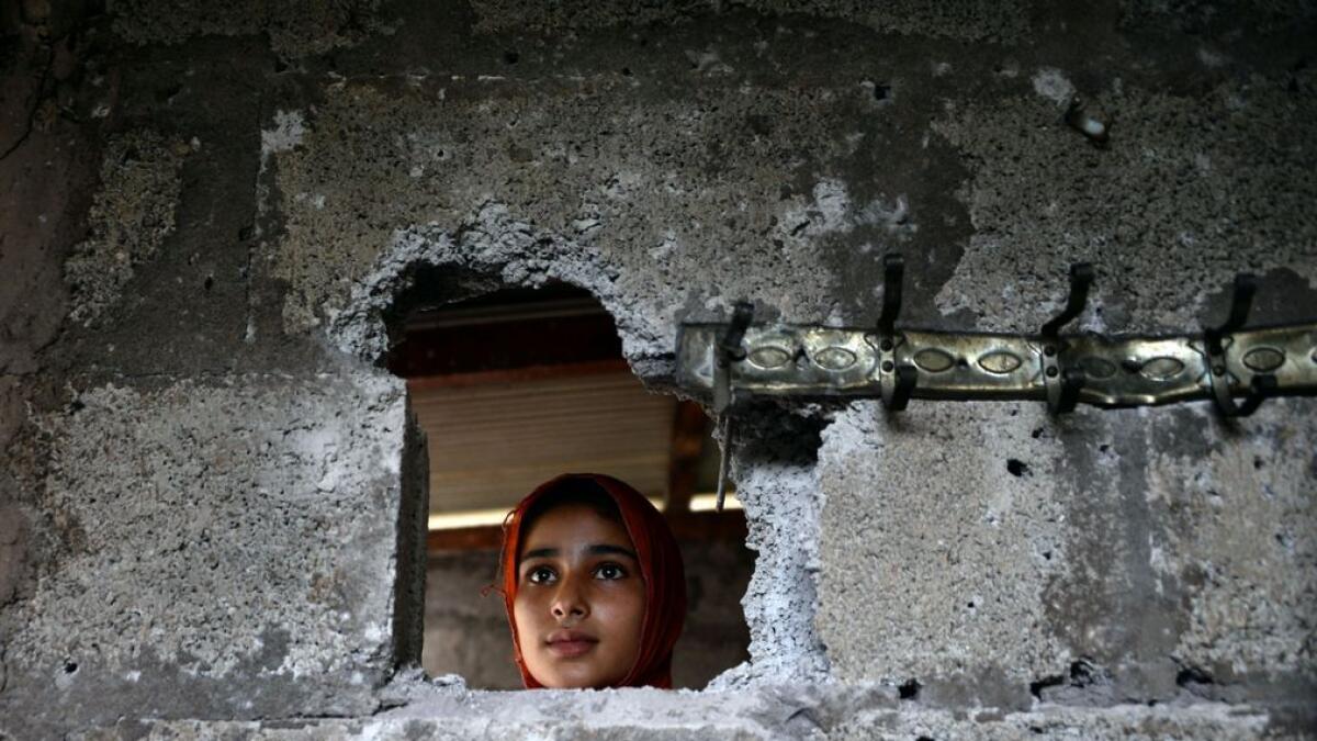 A Kashmiri, affected by cross border firing, shows the damaged wall hit by mortar shell at her home in Dhair Bazar, Madarpur sector on the on the Line of Control (LoC). 