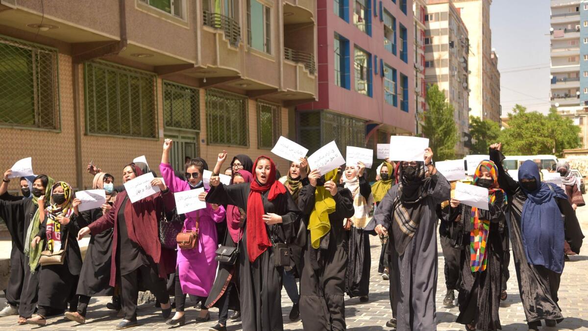 Afghan women hold placards as they march to protest for their rights in Kabul on Saturday. — AFP