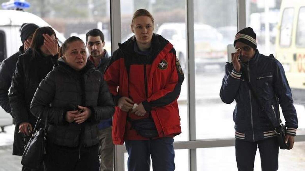 Relatives and acquaintances of victims of the crashed Flydubai Boeing 737-800, accompanied by a psychologist of the Russian Emergencies Ministry (2nd R), enter a building of the airport of Rostov-On-Don, Russia.