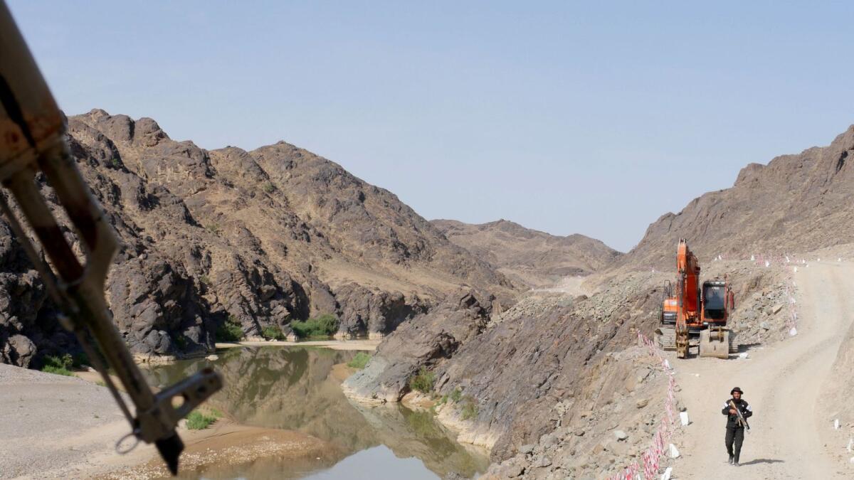 A Taliban security personnel walks along the roadside during the inauguration ceremony of Bakhshabad Dam. — AFP file