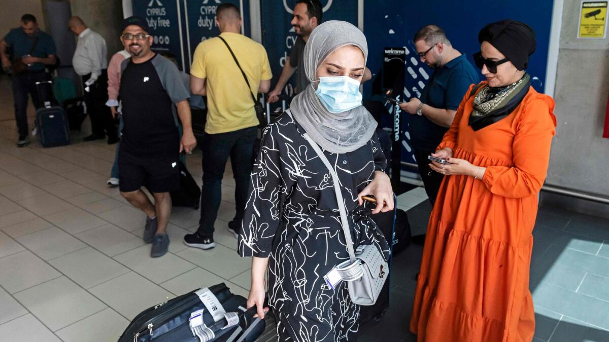 Palestinians leave Larnaca International Airport after arriving aboard the first flight from Israel's Ramon airport, in Cyprus on Monday. — AFP