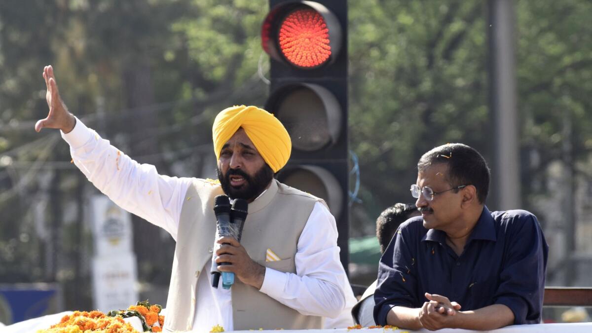 File. Aam Aadmi Party (AAP) leader and Delhi's chief minister Arvind Kejriwal (R) and party's Punjab chief minister-elect Bhagwant Mann address to AAP supporters during a roadshow to celebrate the party's victory in the Punjab assembly elections, in Amritsar on March 13, 2022. Photo: AFP