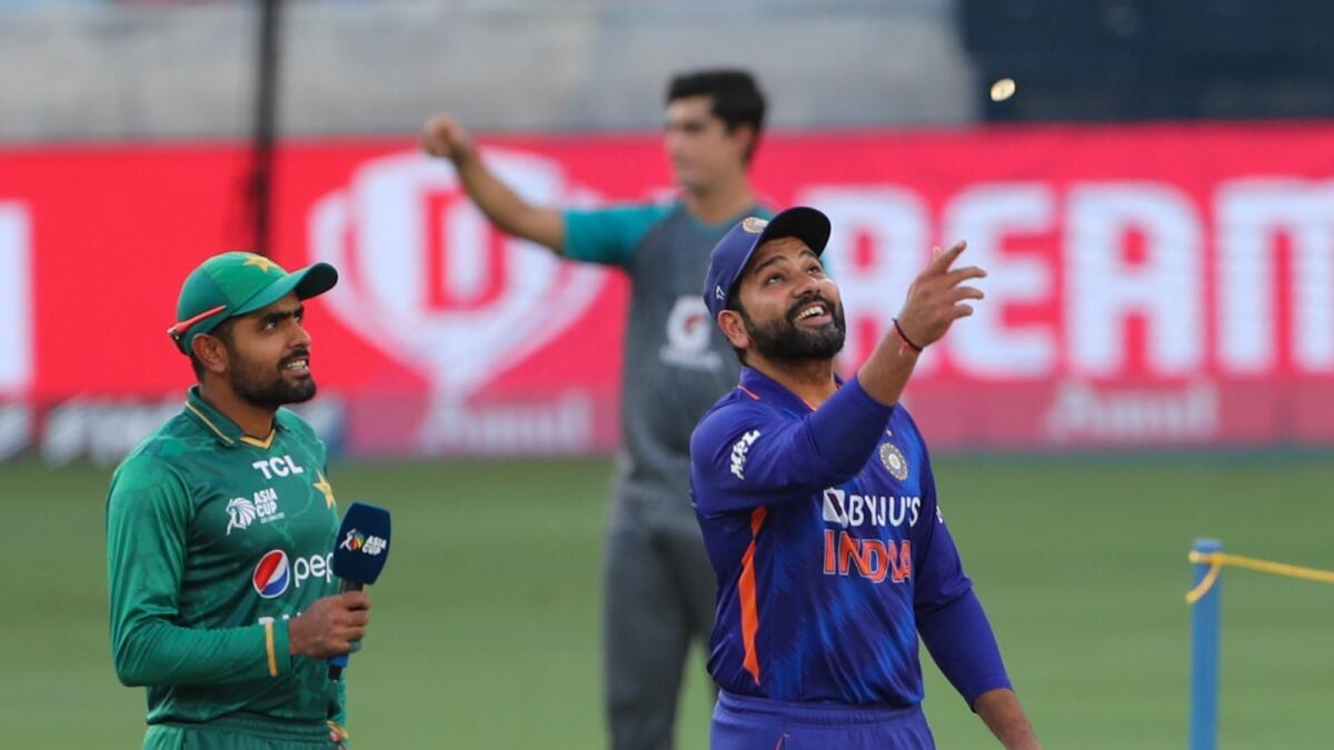 Indian captain Rohit Sharma (right) and Pakistan skipper Babar Azam during the toss at the Dubai International Cricket Stadium on Sunday. — AFP
