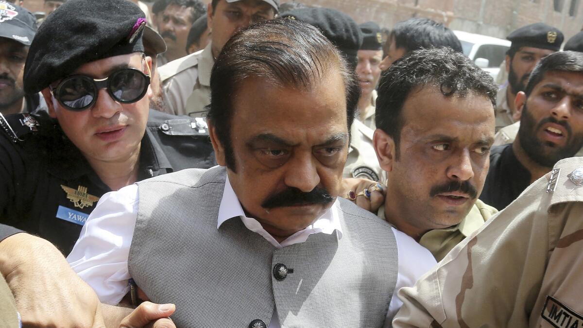Officers of Pakistan's police and Anti-Narcotics Force escort Rana Sanaullah Khan, centre, to present him in a court in Lahore on July 2, 2019. — AP file