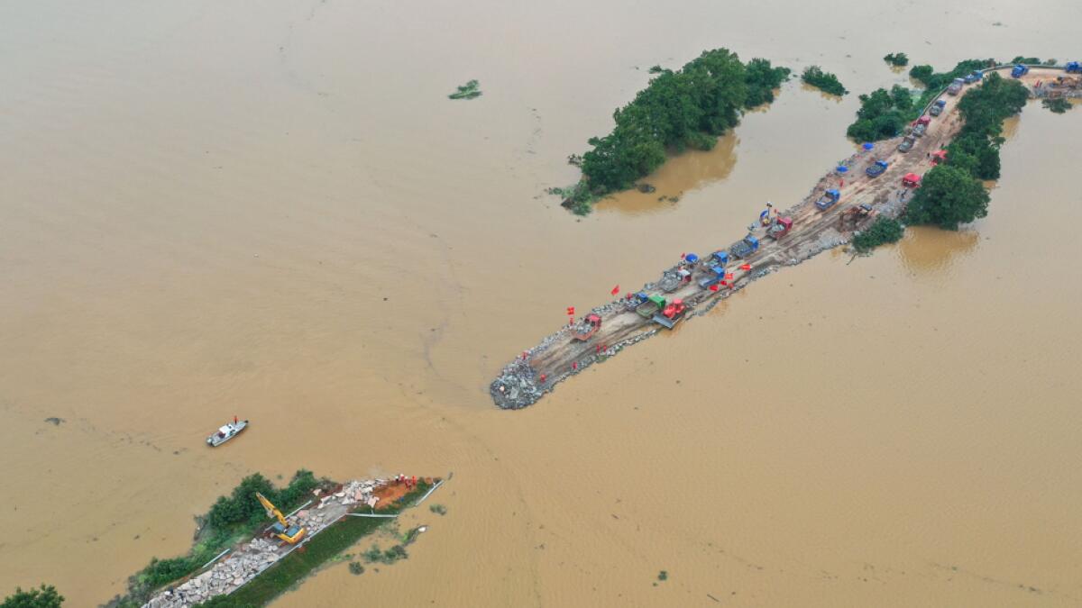 Workers repairing a breached dam due to flooding in Jiujiang in China's central Jiangxi province. Floods across central and eastern China have left more than 140 people dead or missing and are swelling major rivers and lakes to record-high levels, with authorities warning that the worst was yet to come. Photo: AFP