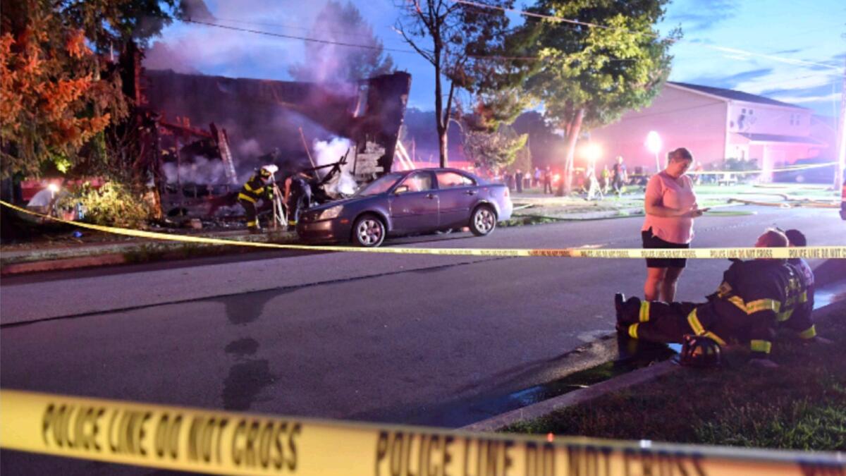 Firefighters set up lights in front of a fatal house fire at 733 First Street in Nescopeck, Pennsylvania. — AP