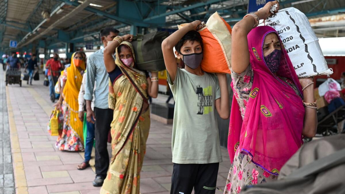 Long-distance travellers queue up at a railway station in Mumbai. Photo: AFP